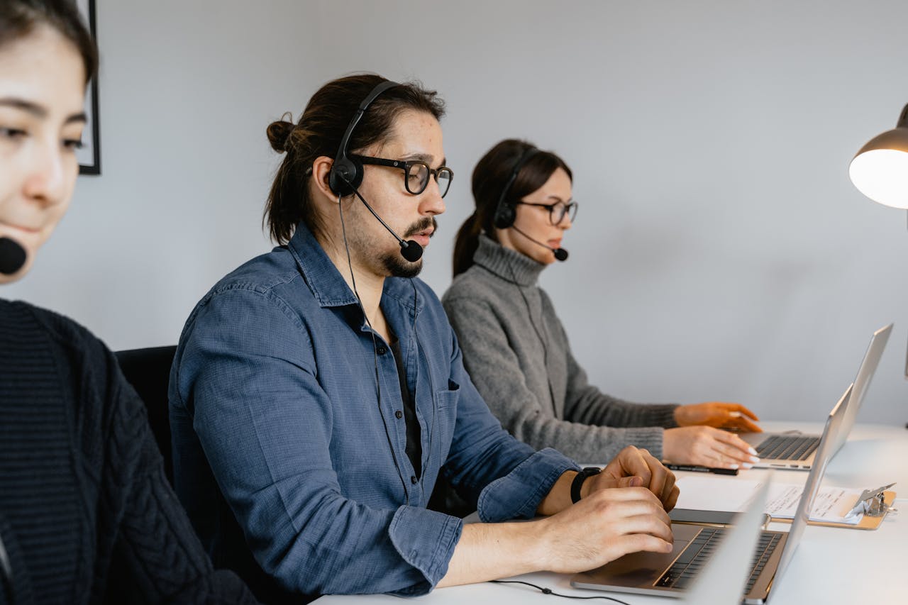 Home Customer service team at call center using laptops and headsets.